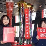 神戸ポートタワー１００万人目の来場者となり、記念品を受け取る東美沙さん（左）。右は司会者の女性＝４日午前、神戸市中央区波止場町（撮影・大田将之）