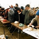 激震地では家族や知人との連絡手段がなくなり、仮設電話は安否を伝える人たちでごった返した＝１９９５年１月１８日、神戸市長田区、蓮池小学校