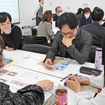 生理痛の疑似体験をする男性（右から２人目）。スイッチを入れると次第に複雑な表情を見せた＝神戸市中央区三宮町１