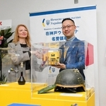 セレモニーで握手を交わすインナ・イリナさん（左）と岡部芳彦教授＝神戸市中央区港島１