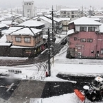 雪が降る中、除雪作業にあたる車両＝２６日午前、朝来市、朝来市役所前（撮影・小日向務）