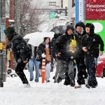 雪が積もる中、市街地を歩く高校生ら＝２６日午前、豊岡市若松町（撮影・大高碧）