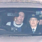 警察車両で送検される立花孝志容疑者（中央）＝１１月１０日、神戸市中央区下山手通５