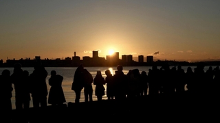 神戸ポートアイランド越しに昇る初日の出。静かな海をオレンジ色に染めた＝１日午前７時２２分、神戸市中央区東川崎町１から（撮影・風斗雅博）