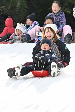 人工雪の斜面で元気にそり遊びをする子どもら＝６日、神戸市灘区六甲山町北六甲、六甲山スノーパーク