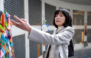 希ちゃんの銘板がある瞑想（めいそう）空間を訪れ、千羽鶴に触れる小西眞希子さん＝神戸市中央区、東遊園地（撮影・鈴木雅之）