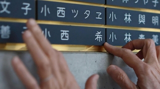 希ちゃんの銘板をなでる小西眞希子さん＝神戸市中央区加納町６、東遊園地（撮影・鈴木雅之）
