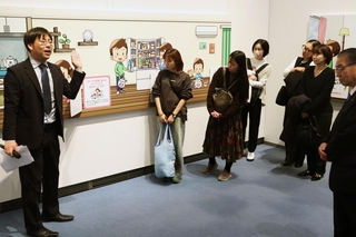 スタッフが内容を説明しながら展示を見て回った内覧会＝神戸市中央区浜辺通６