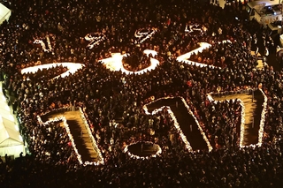 「つむぐ　１．１７」と形作られた灯籠に火がともされ、祈りに包まれる東遊園地＝１７日午前５時４６分、神戸市中央区加納町６（撮影・長嶺麻子）