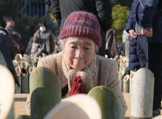 三輪教子さんは亡くなった長女純子さんを思いながら竹灯籠に手を合わせた＝１７日午前１０時１０分、神戸市中央区加納町６、東遊園地（撮影・大田将之）