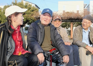 ボランティア仲間と仮設住宅があった西代蓮池公園を訪れた長尾政三さん（左から２人目）＝１７日午後３時半、神戸市長田区蓮池町