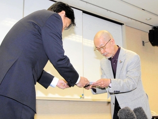 神戸市の福本靖教育長（左）に調査報告書を手渡す第三者委員会の羽下大信委員長＝１９日午後、神戸市中央区東川崎町１、神戸市総合教育センター