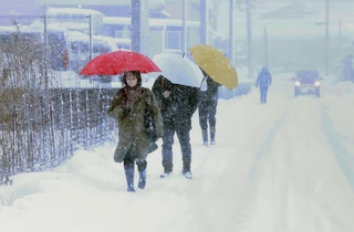 雪が降り積もる中、歩いて出勤する人たち＝22日午前、兵庫県香美町香住区香住（撮影・長谷部崇）