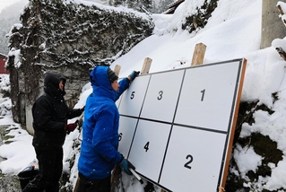 衆院選のポスター掲示板を設置する業者の男性。雪が積もりやすい山間部から先に回ったという＝21日午後、兵庫県新温泉町岸田（撮影・長谷部崇）