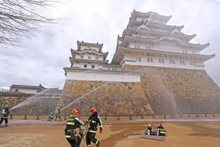 姫路城の大天守に向かって放水する消防隊員＝２６日午前、姫路市本町