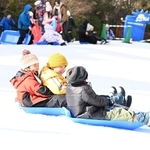人工雪の斜面で元気にそり遊びをする子どもら＝６日、神戸市灘区六甲山町北六甲、六甲山スノーパーク