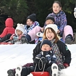 人工雪の斜面で元気にそり遊びをする子どもら＝６日、神戸市灘区六甲山町北六甲、六甲山スノーパーク