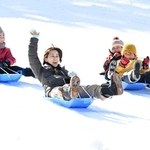 人工雪の斜面で元気にそり遊びをする人たち＝６日、神戸市灘区六甲山町北六甲、六甲山スノーパーク