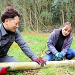 伐採した竹を竹筒の形に整える浜崎真乃さん（右）とＨＡＮＤＳの藤本真一さん＝神戸市須磨区多井畑