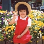 花壇に座り、はにかむ小西希ちゃん＝１９９４年５月３日、神戸市灘区（小西眞希子さん提供）