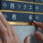 希ちゃんの銘板をなでる小西眞希子さん＝神戸市中央区加納町６、東遊園地（撮影・鈴木雅之）