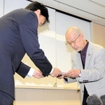 神戸市の福本靖教育長（左）に調査報告書を手渡す第三者委員会の羽下大信委員長＝１９日午後、神戸市中央区東川崎町１、神戸市総合教育センター