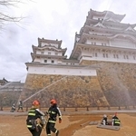 姫路城の大天守に向かって放水する消防隊員＝２６日午前、姫路市本町