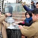 「１．１７希望の灯り」の火を輪島市へ。届けるランタンに火を移す参加者たち＝１月31日午後、神戸市中央区加納町６、東遊園地