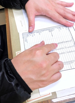 血液検査の結果を示す男性。半年に一度の通院が欠かせない＝西宮市内