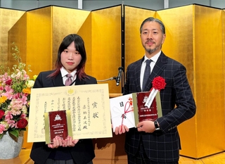 引率者と並んで賞状を手にする嘉納美波さん（左）＝東京都内