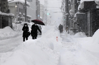 大雪の中、豊岡市街を歩く人ら＝８日午後、同市中央町（撮影・大高　碧）