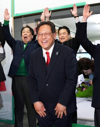 万歳で喜ぶ支援者に囲まれ、笑顔の関芳弘氏＝神戸市須磨区大池町２（撮影・合田純奈）