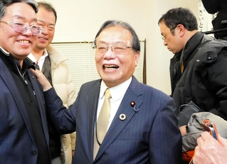 当選確実の知らせを受け、支援者らと喜ぶ谷公一氏（中央）＝豊岡市寿町（撮影・吉田みなみ）