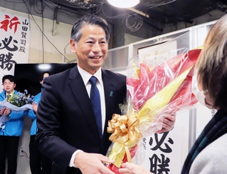 支援者から花束を受け取った山田賢司氏＝西宮市羽衣町（撮影・中村有沙）