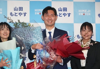 支援者から花束を贈られ、感極まった表情の山田基靖氏（中央）＝姫路市東延末２（撮影・辰巳直之）