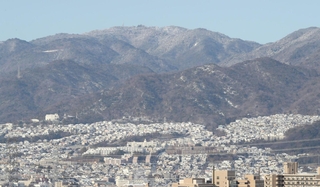 寒波で冠雪した六甲山。山麓に広がる住宅街も白く覆われた＝９日午前、伊丹市内から（撮影・小林良多）