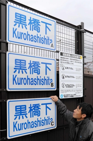 ３枚の「黒橋下」の標識が並ぶ。表面の塗料や素材を変えて耐久性を調べる＝明石市大蔵町