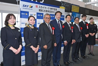 開港２０年のセレモニーに臨む神戸市の久元喜造市長（左から４人目）とスカイマークの本橋学社長（同５人目）ら＝１６日午前、神戸市中央区、神戸空港（撮影・大田将之）