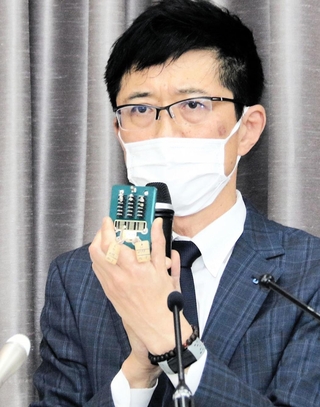 部品を手に、踏切が動かなかった原因などを説明するＪＲ西日本鉄道本部電気部の山本大弘部長＝17日午後、大阪市北区