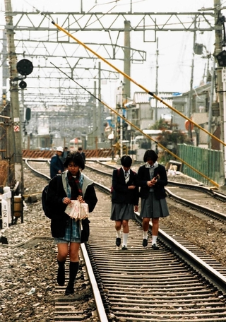 不通になった山陽電鉄板宿－東須磨間の線路を歩いて帰宅する女子高校生＝１９９５年３月４日、神戸市須磨区大手町