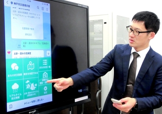 ラインの「神戸市災害掲示板」を拡大画面で説明する市担当者＝神戸市役所