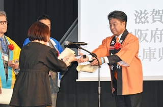 「ロケーションジャパン大賞」のグランプリに選ばれ、表彰を受ける門間雄司豊岡市長（右）＝東京都渋谷区