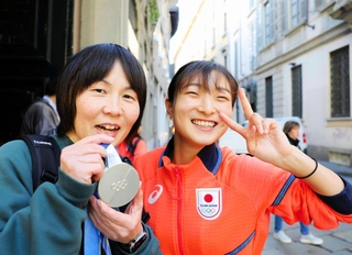 中学時代の恩師の関口清香さん（左）に銀メダルを手渡し、笑顔を見せる坂本花織＝ミラノ市内（撮影・吉澤敬太） 
