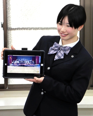 生徒らで制作した応援動画を手に坂本選手への思いを語る神戸野田高校の垣内葵子さん＝神戸市長田区海運町６