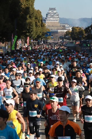 姫路城を背に一斉にスタートするランナー＝２２日午前、姫路市の大手前通り（撮影・辰巳直之）