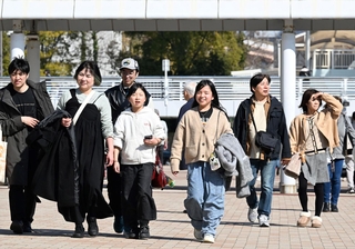 暖かな陽光が降り注ぐ中を歩く人たち＝２２日午後、神戸市中央区波止場町（撮影・斎藤雅志）