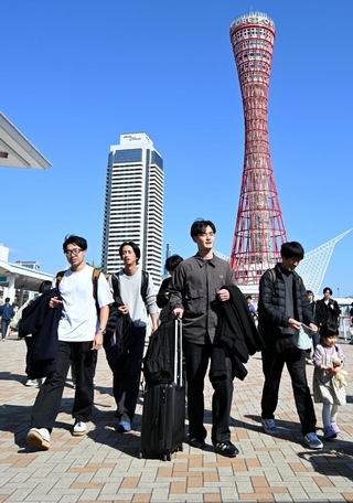 暖かな陽光が降り注ぐ中を歩く人たち＝２２日午後、神戸市中央区波止場町（撮影・斎藤雅志）