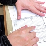 血液検査の結果を示す男性。半年に一度の通院が欠かせない＝西宮市内