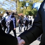 受験会場へ入る高校生と、応援に駆けつけた高校教諭ががっちり握手＝西宮市上ケ原一番町、関西学院大学（撮影・吉田敦史）