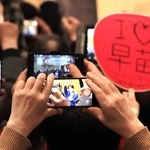 自民党総裁の高市早苗首相を捉えるスマホと「Ｉ♡早苗」のうちわ＝西宮市内